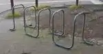 single metal tube bent into multiple large loops, similar to stands