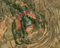 5/6 Communication tower (man_made=tower and tower:type=communication), with an antenna and a small building, on top of a plain (Maxar satellite imagery).