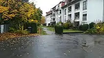 Die Aufstell- und Bewegungsfläche auf dem Grundstück befindet sich hinter den Pollern. Der Belag ist mit Rasengittersteinen befestigt. Zeitgleich dient er als Gehweg zum erreichen der Hauseingänge.
