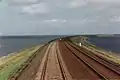 Railroad causeway on top of an embankment.