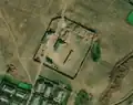 1/6 Farmyard (landuse=farmyard) surrounded by a fence dotted with hay piles, crossed by a road (Maxar satellite imagery).