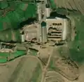 6/6 Farmyard (landuse=farmyard) composed of long buildings dotted with hay piles. Messy cemetery in lower right of image (see section on cemeteries for more detail) (Maxar satellite imagery).