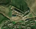 3/6 Farmyard (landuse=farmyard) surrounded by a fence dotted with hay piles, close to a road very close to a village (Maxar satellite imagery).