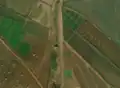 2/4 Pumping station (man_made=pumping_station) isolated at the end of a watercourse and close to a road (Maxar satellite imagery).