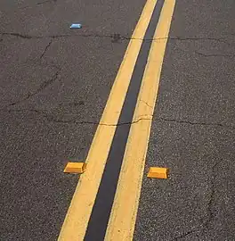 studs – small safety devices like Botts' dots/road studs/raised pavement markers that can be easily passed over but give a tactile or auditory feedback.
